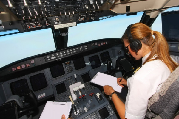 female pilot sitting in the cockpit of a passenger plane